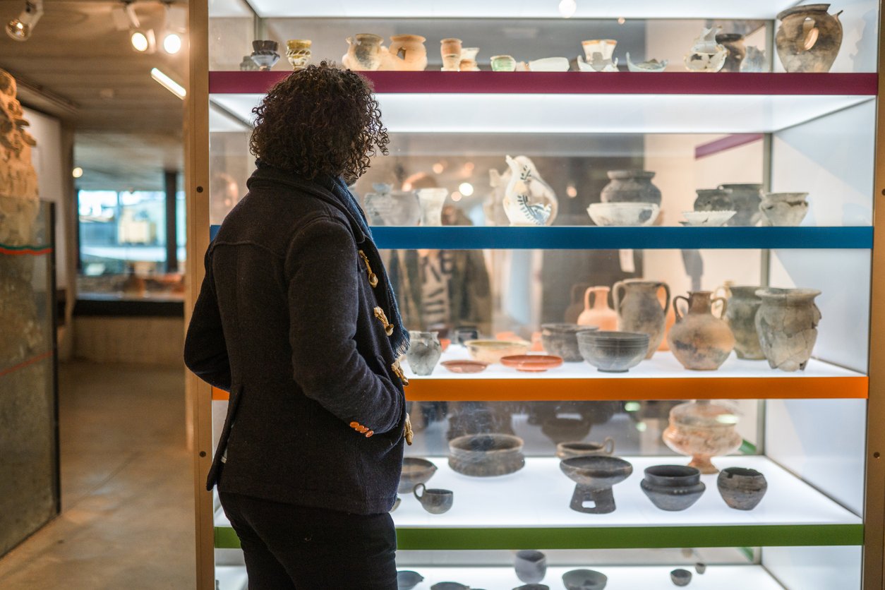 museum visitor looking at ancient pottery 